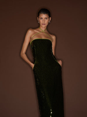 Close up front view of a model leaning against a dark brown wall wearing the Cactus 09 Audrey Dress