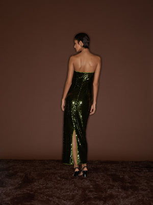 Back view of a model wearing the Cactus 09 Audrey Dress on top of dark brown background