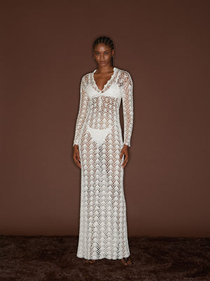 Front view of a female figure wearing the White 09 Crochet Dress on top of a brown background