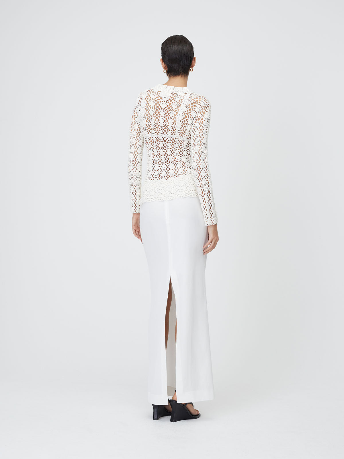 Back view of a model wearing the White 9 Crochet Top on top of a white background