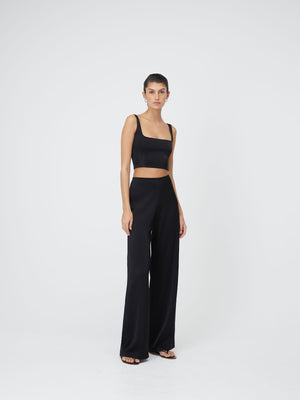 Front view of a model wearing the Black Marnie Pants and a dark top