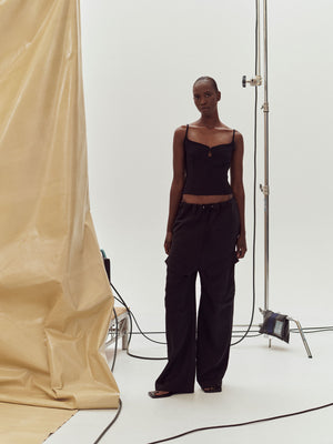 A model standing near photography equipment wearing Black Marlo Singlet