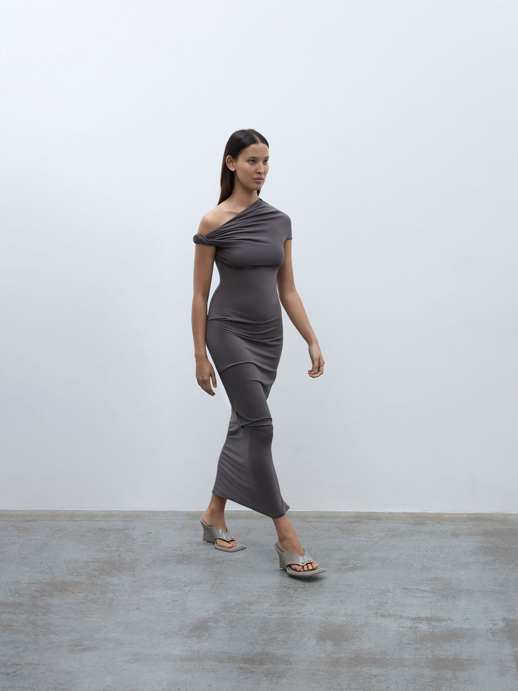 Side profile of a model walking wearing the 05 Elemental Ida Dress in mushroom colour