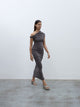 Side profile of a model walking wearing the 05 Elemental Ida Dress in mushroom colour