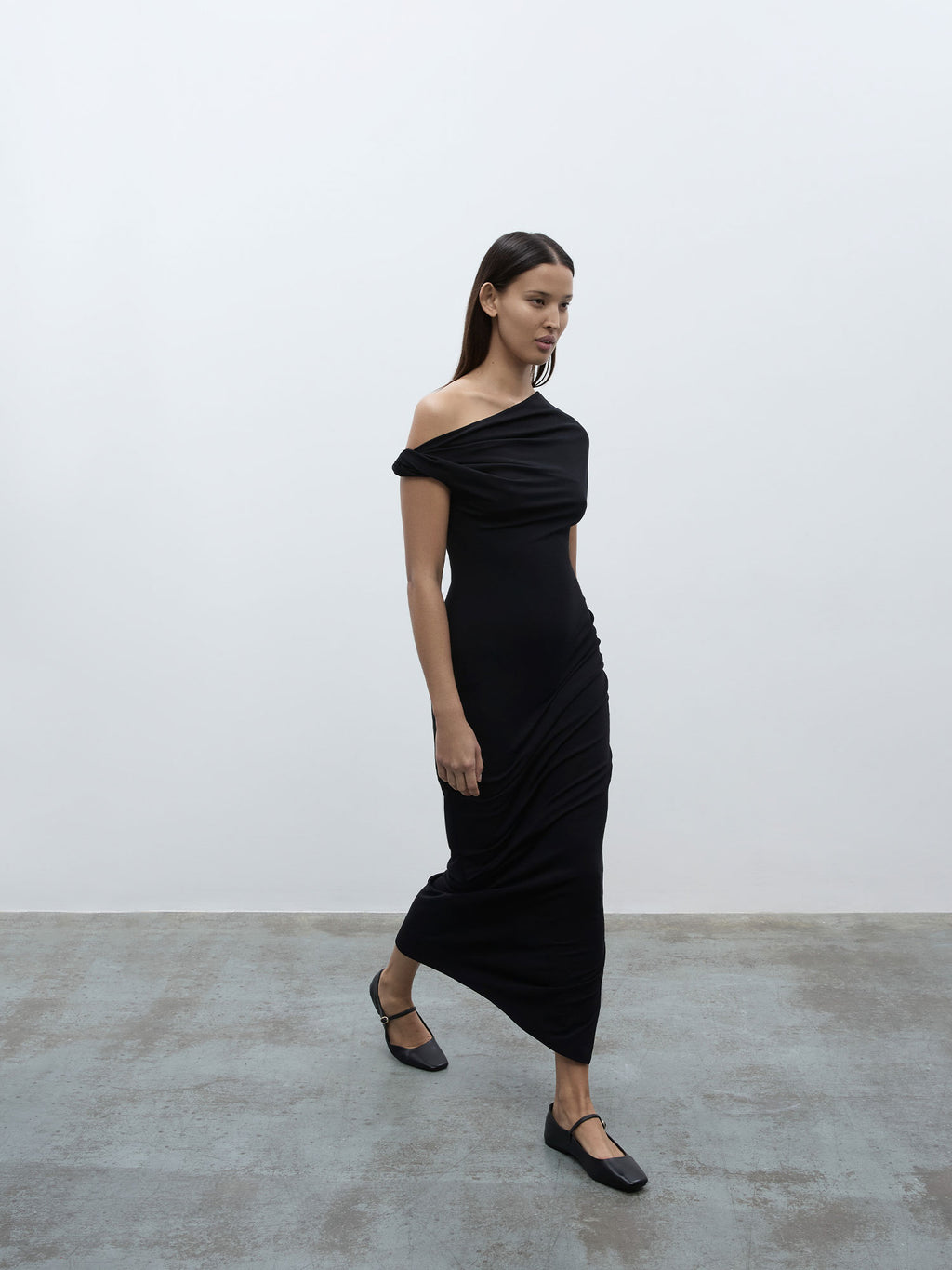 A model walking wearing the 05 Elemental Ida Dress in black