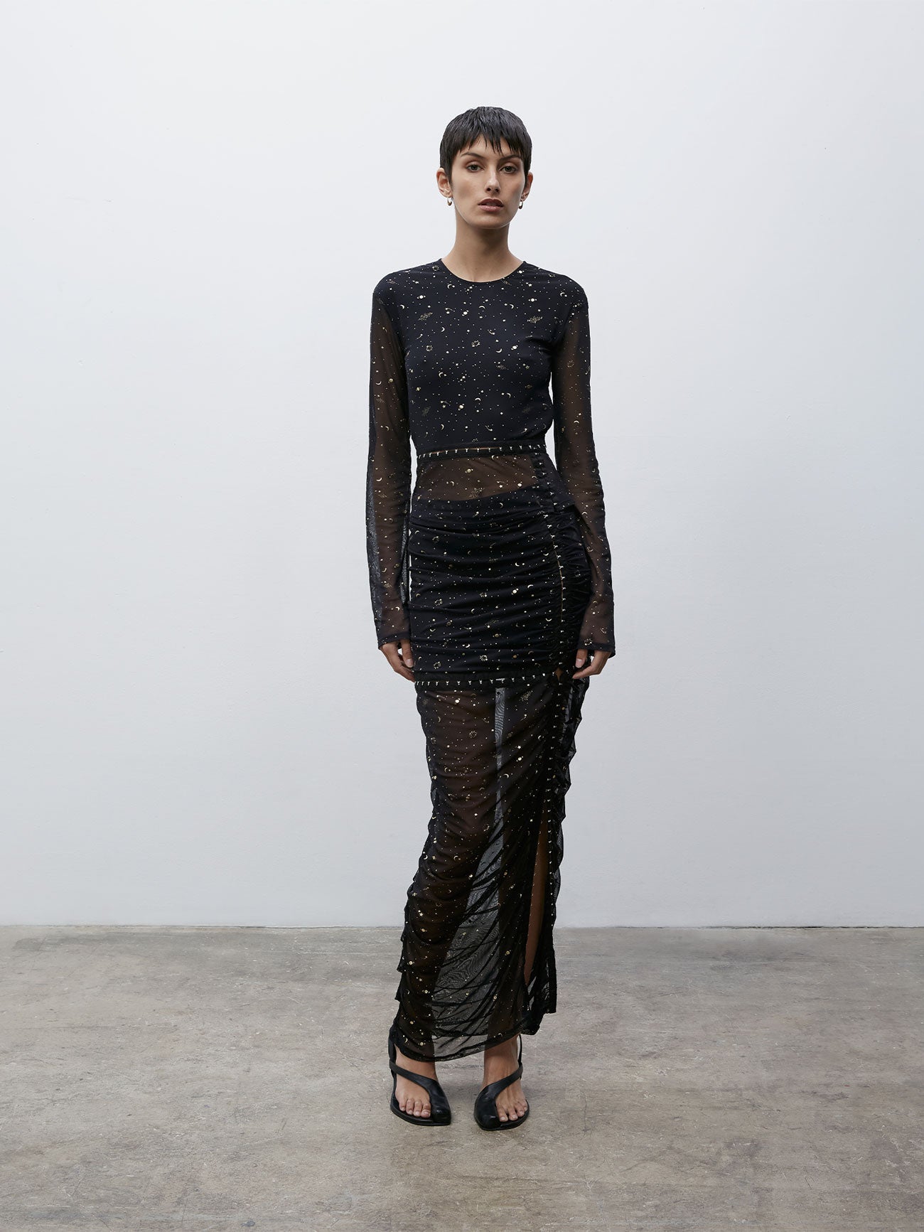 Front view of a model wearing a Black and Gold 09 Galaxy Skirt and 09 Galaxy Top