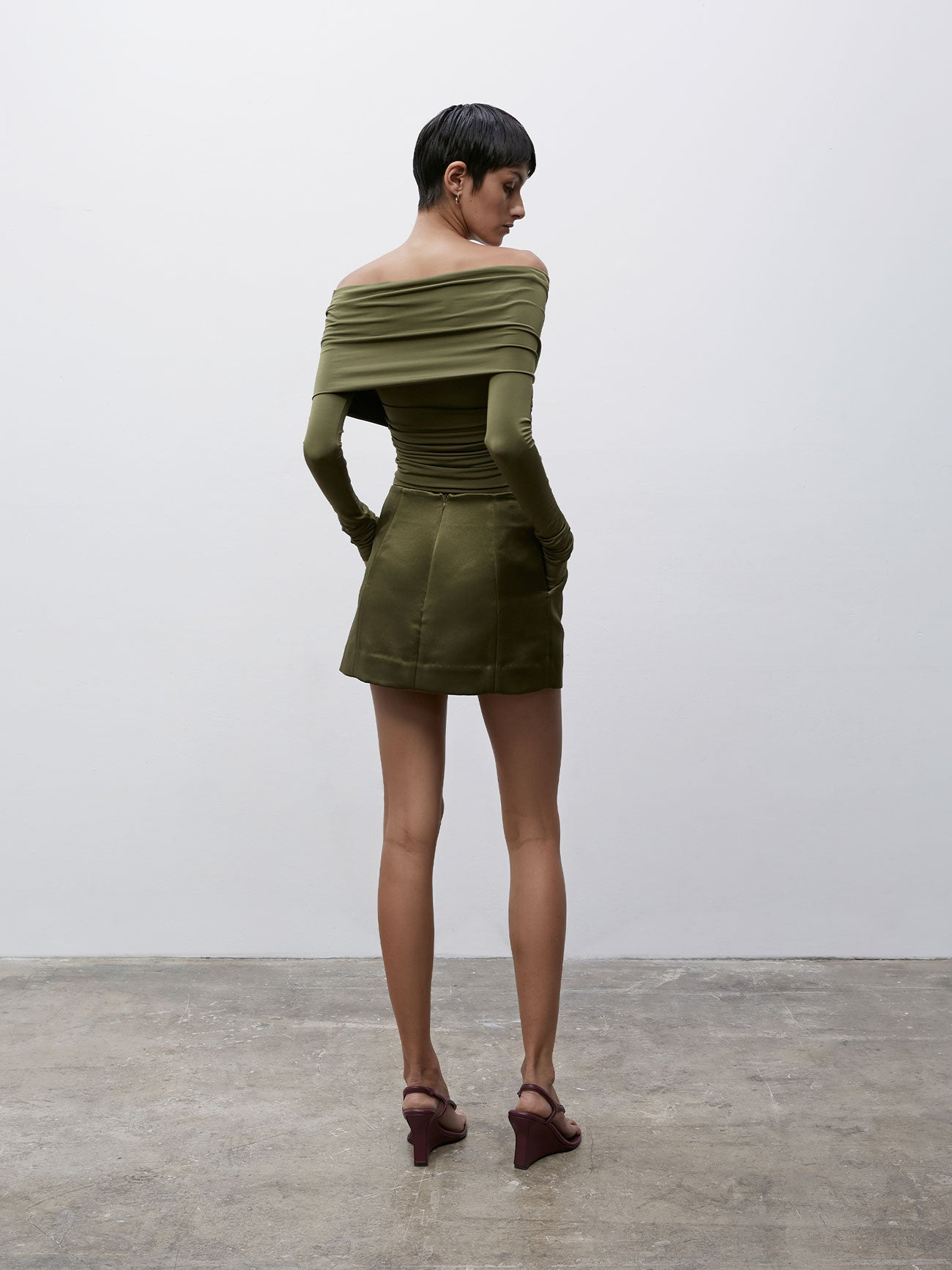 Back view of a model wearing matching Olive 09 Cass Mini Skirt and top