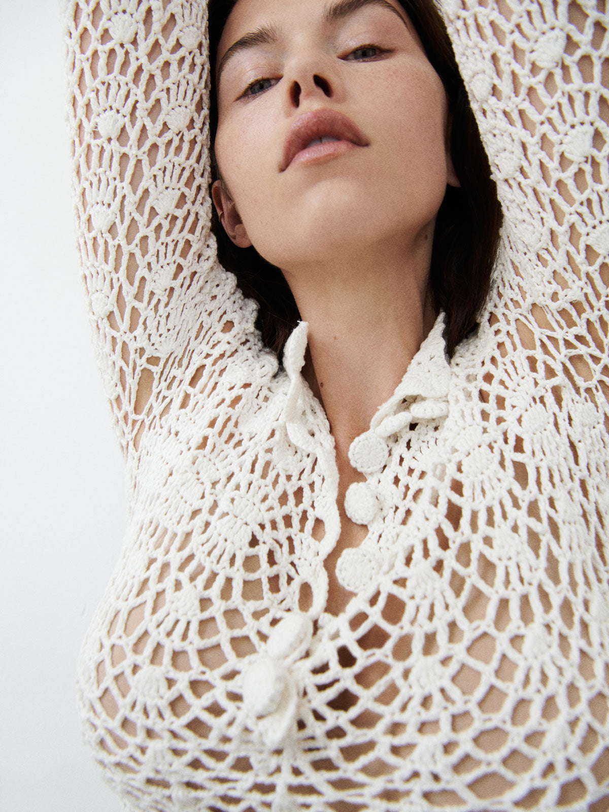 Close up view of a model wearing the White 9 Crochet Top