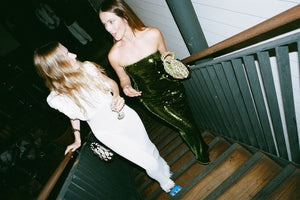 Two female figures walking up a staircase and one is wearing the Cactus 09 Audrey Dress
