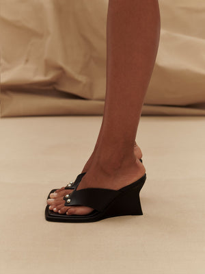 Side view of model wearing Paris Georgia Black Dune Wedge Shoes